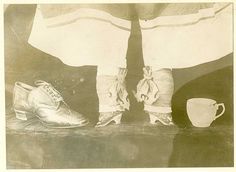 The bound feet of a Chinese woman, compared to a teacup on the right, and normal woman's shoe at left.
