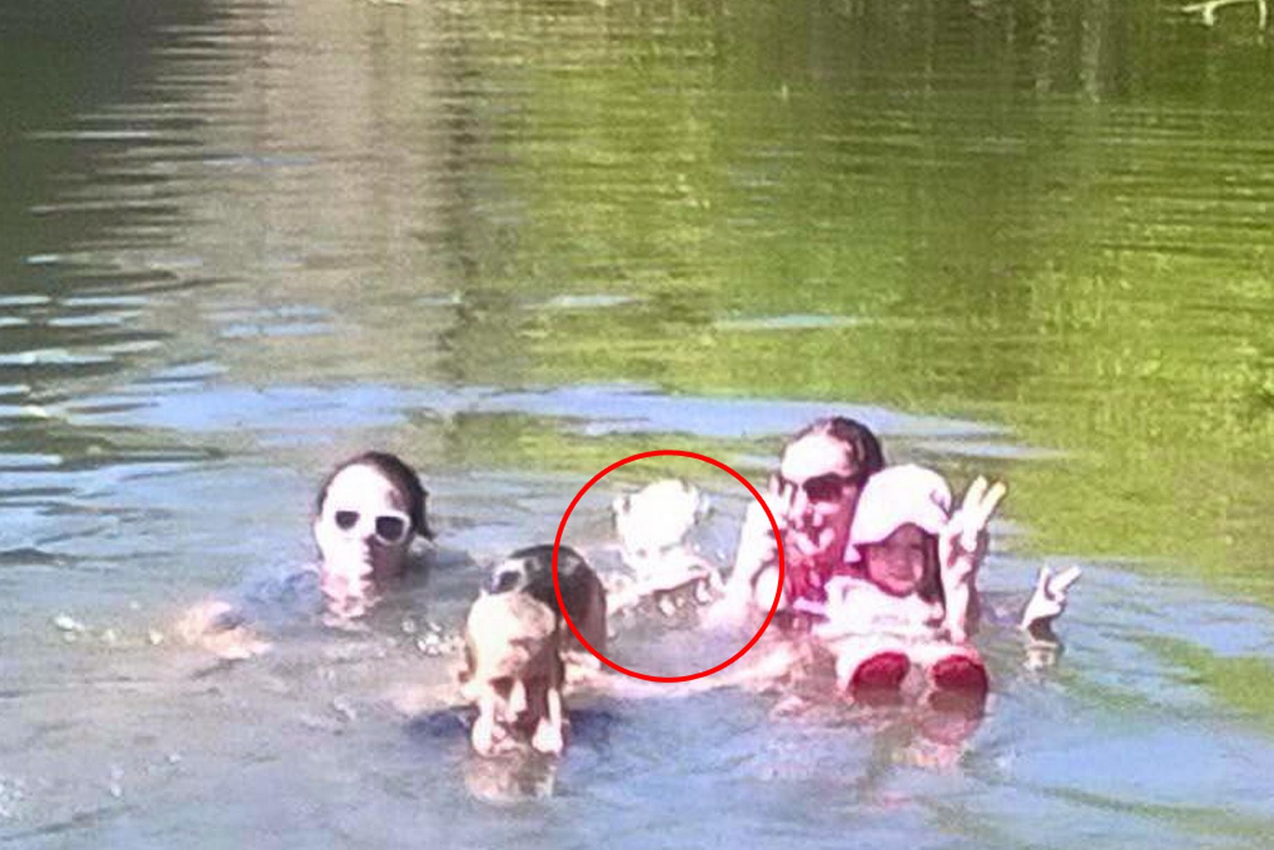 The girl in the center is not part of this family, nor was anyone else swimming with them when this photo was taken.