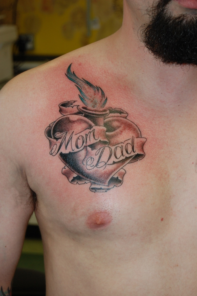 guy with a heart tattoo dedicated to his mom and dad