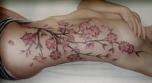A tattoo of a tree branch on a womans left side