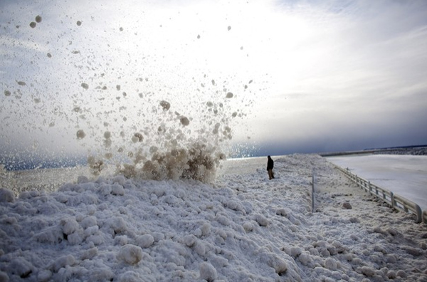 A man watches as large chunks of ice crash into the break wall at the Milwaukee Marina in Wisconsin.