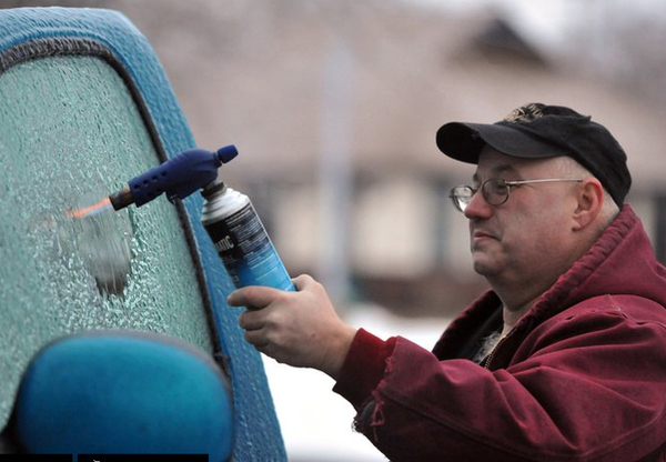 Gary Phillips uses a $10.00 torch to melt the ice on a $30,000 truck in Indiana