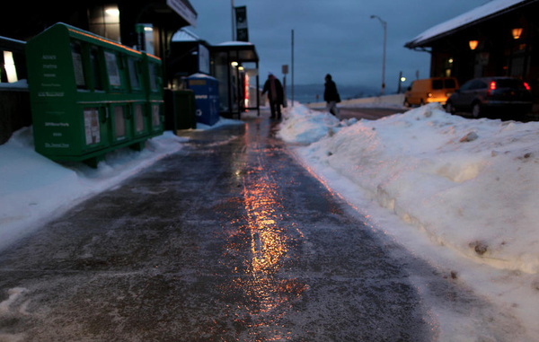 Ice and freezing rain covers sidewalks as early-morning commuters carefully walk to the Metro-North commuter train platform in Ossining, N.Y.