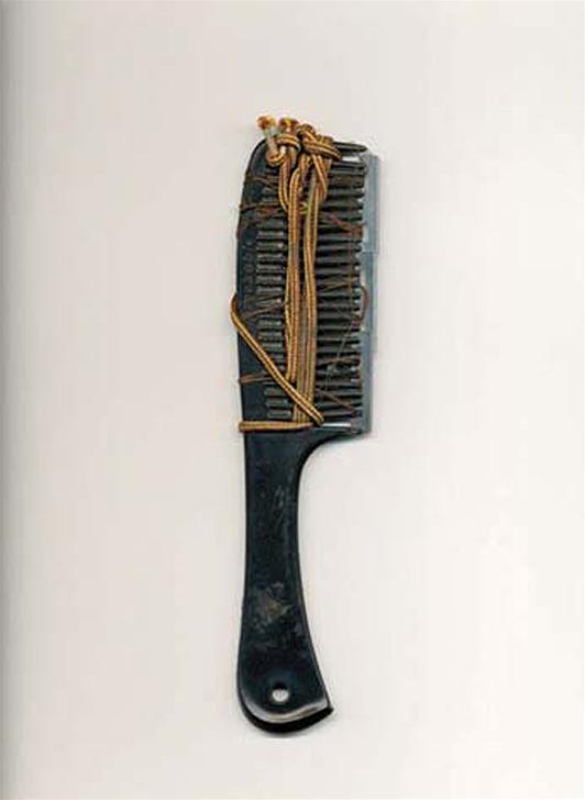 prison shive razor blades installed in the teeth of comb held togather with shoe string
