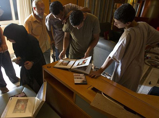 Rebel fighters and civilians browse through Aisha Gaddafi's photo albums  