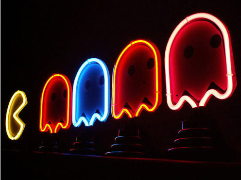 Trippy picture of a neon pacman sign.