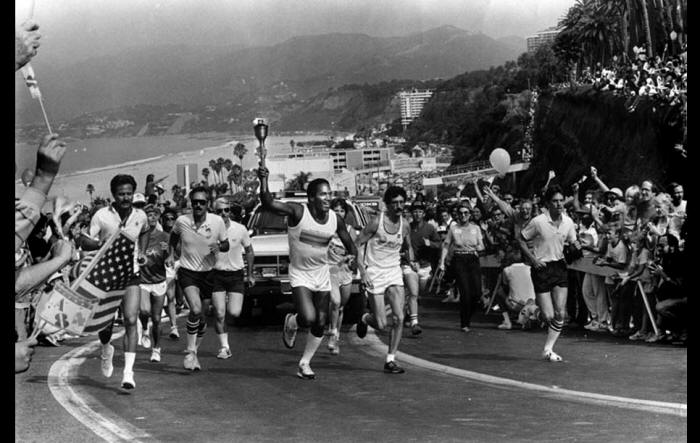 OJ Simpson carries the Olympic Torch in 1984.  Nichole Brown can be seen on the left.