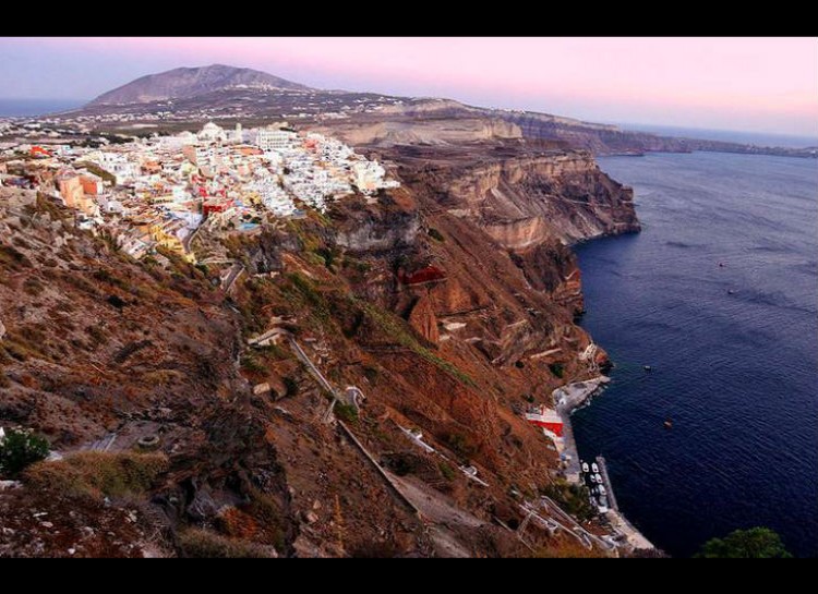 On closer look, the jagged and rugged cliffs below Santorini seem to contradict the festive and laid-back look of the city itself.