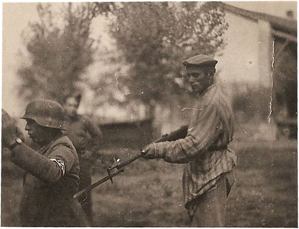 A liberated Jew holds a Nazi guard at gunpoint