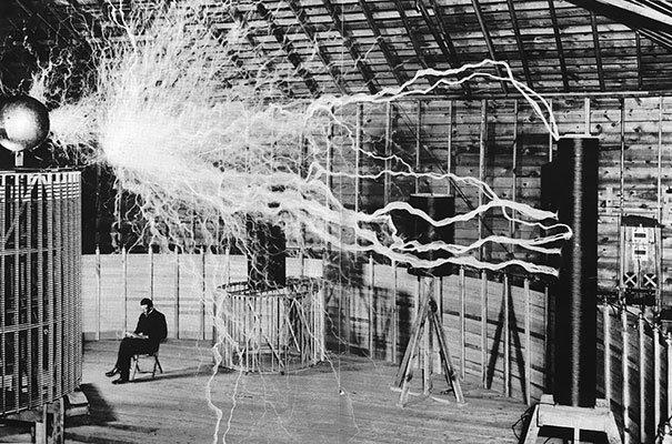 The genius Nikola Tesla calmly sitting and studying his invention – The Magnifying Transmitter