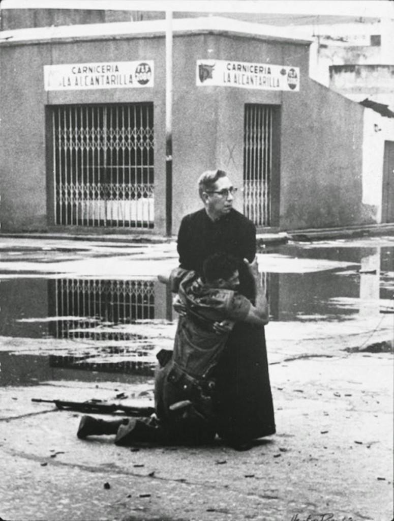 A priest holding a dying soldier in 1962
