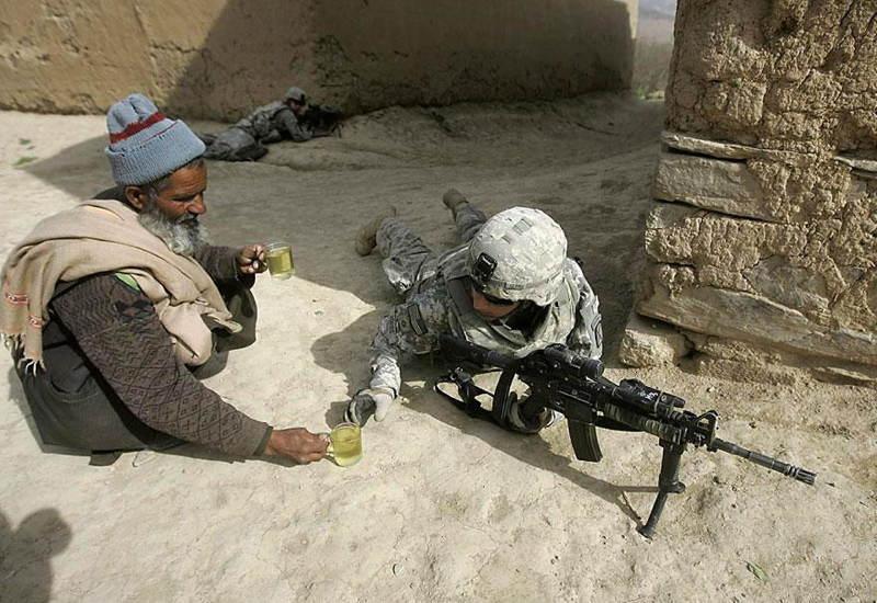 An afghan native offering tea to an American soldier in Afghanistan