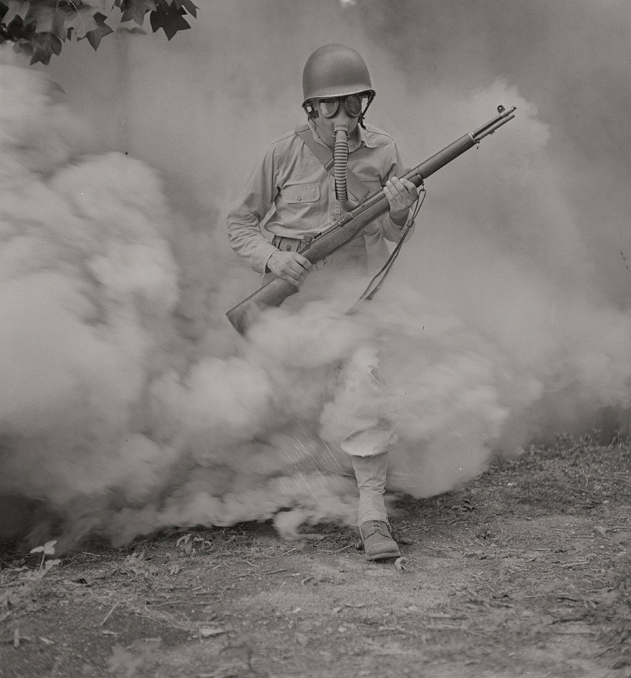 Sergeant George Camblair practicing with a gas mask in a smokescreen  Fort Belvoir, Virginia, 1942