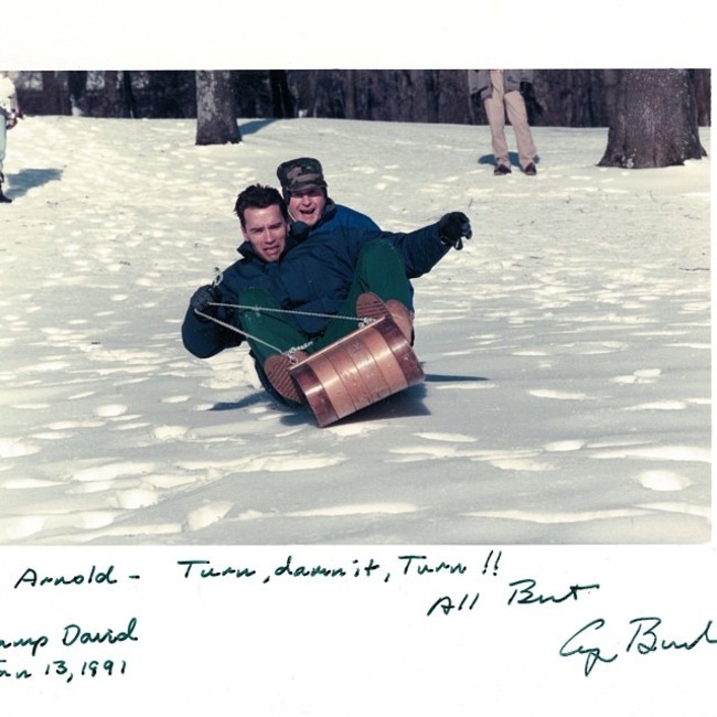 President George H. Bush and Arnold Schwarzenegger sledding together at Camp David.