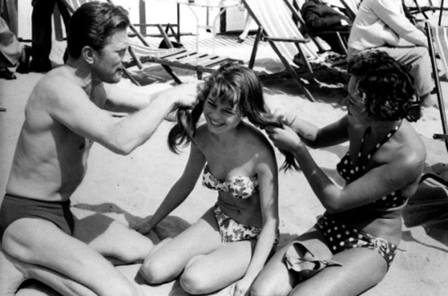Kirk Douglas helping Brigitte Bardot with her hair.
