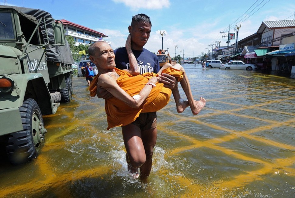 A Thai soldier carries a frail Buddhist monk to safety during flooding.