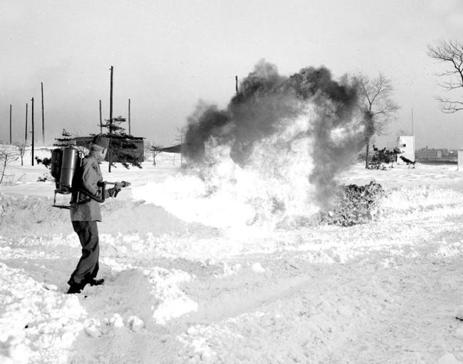 Robert G. Evraets uses a flame thrower to clear a path through the thick snow of Governors Island. December 1947