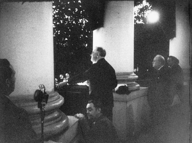 Roosevelt addresses the crowd at the White House Christmas tree lighting ceremony. Winston Churchill is to his right. 1941