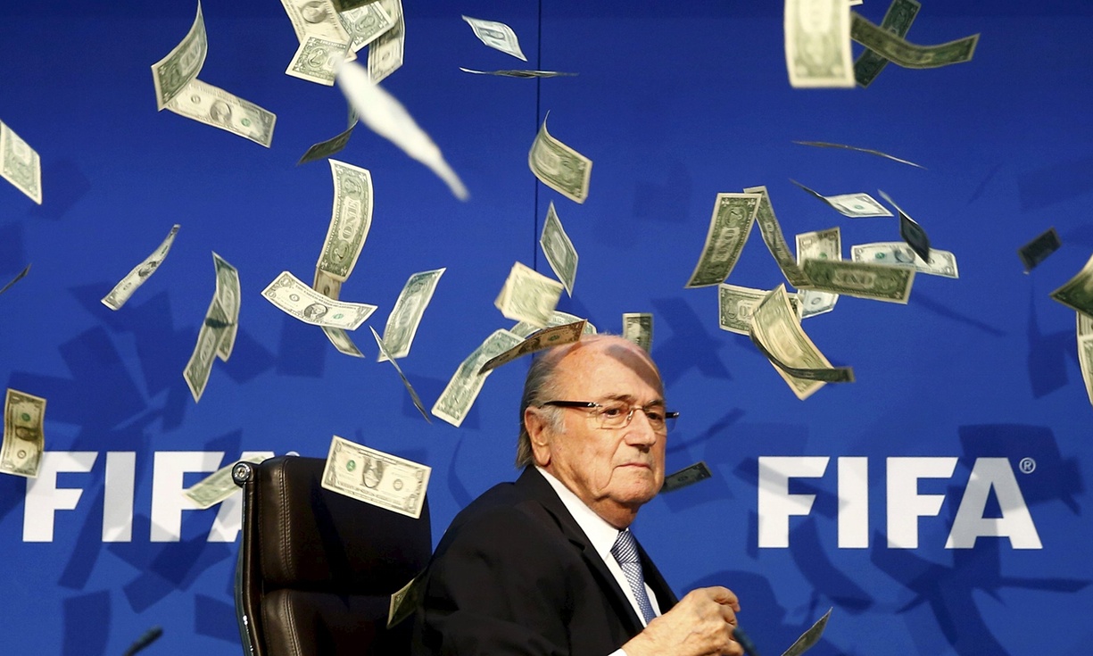 Money, money, money: Sepp Blater (suspended FIFA president) confronts the future after an 8 year league ban as fake dollar bills fall to the ground all around him.