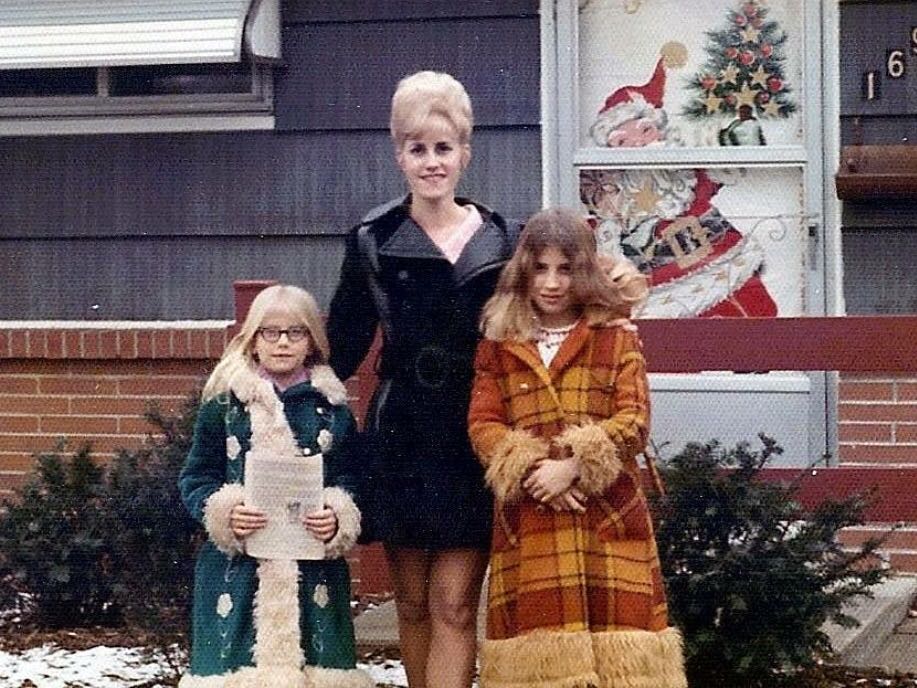 A mother in the 70's wrangling her daughters.