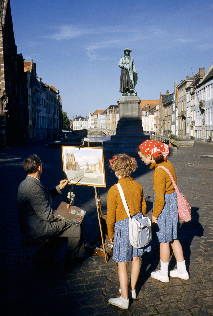 Girls watch artist painting picture of statue of Flemish artist in Bruges, Belgium, May 1955.