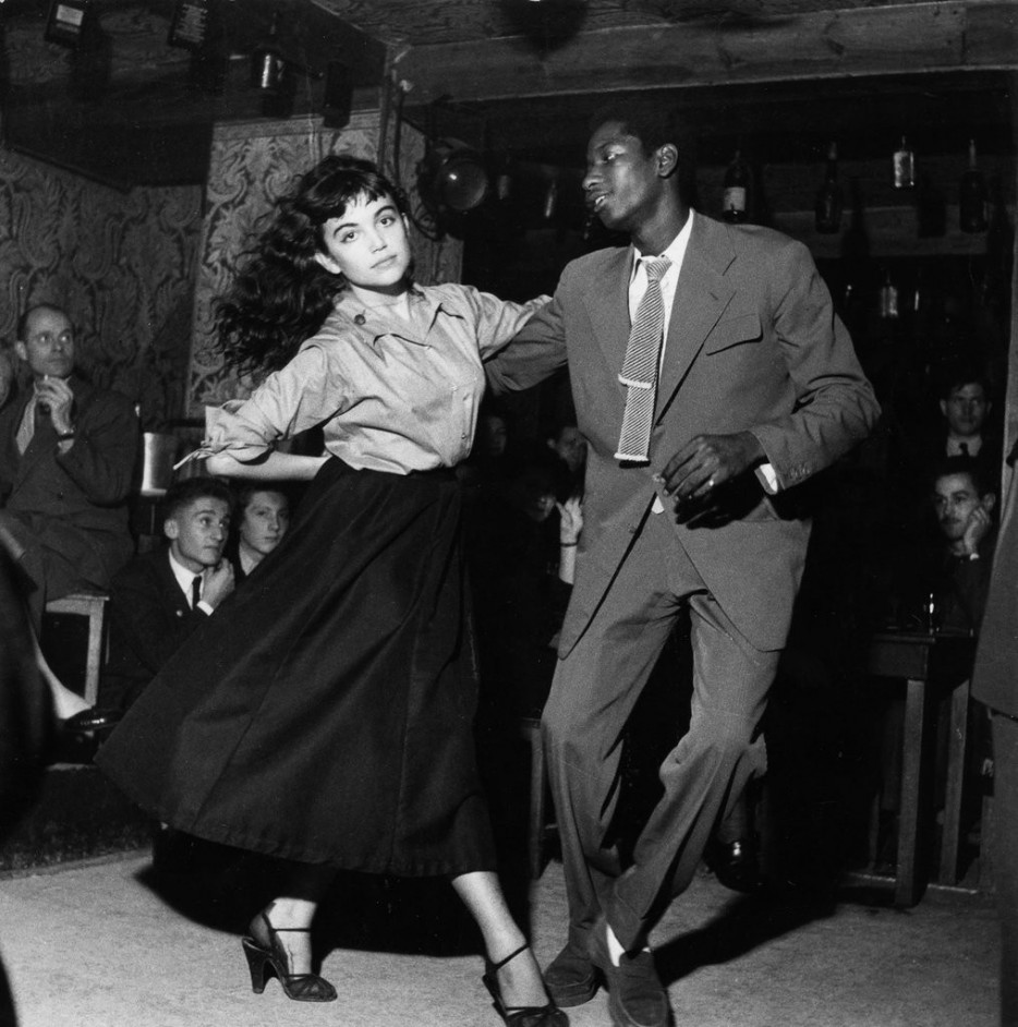 An unusual couple dancing in a 1950's bebop theater.