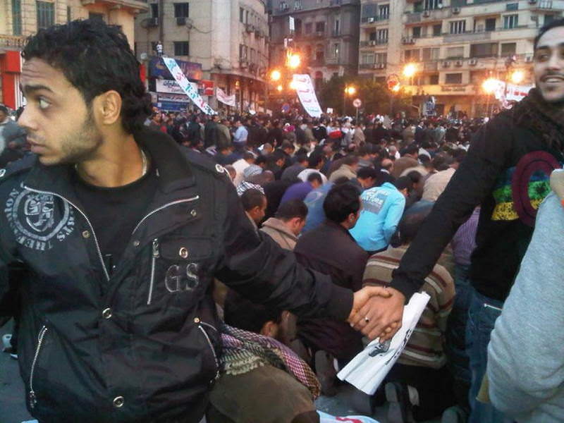 Christians and Muslims hold hands in solidarity during the Cairo uprisings, January 2011.