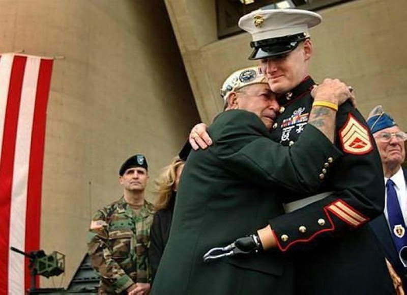 Pearl Harbor survivor embraces a fellow veteran (from the War in Iraq), July 2004.