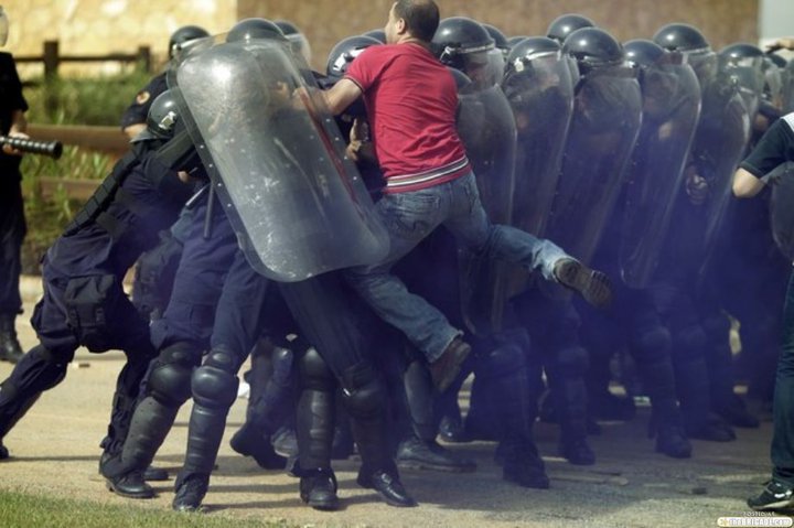 Egyptian protester just throws himself on the riot control police... We'll gotta admit, he's got ballz !