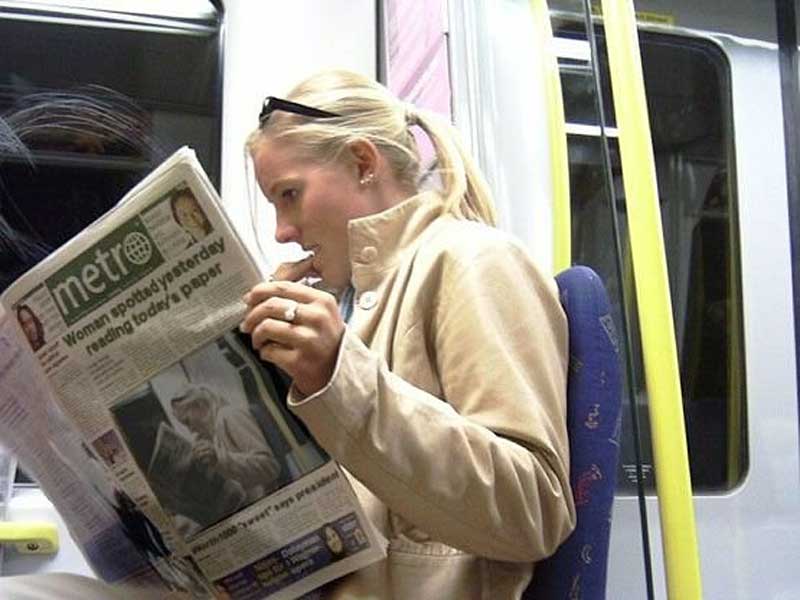 Meme of a woman reading a newspaper in which the pic of her reading is front page news.