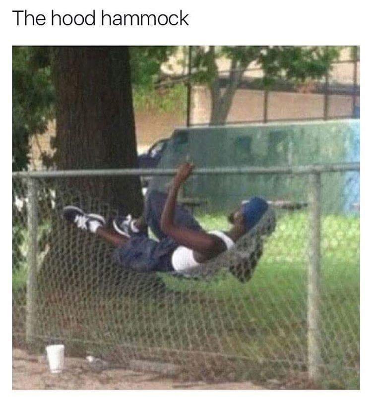 Man chilling out on a broken fence like it is a hammock