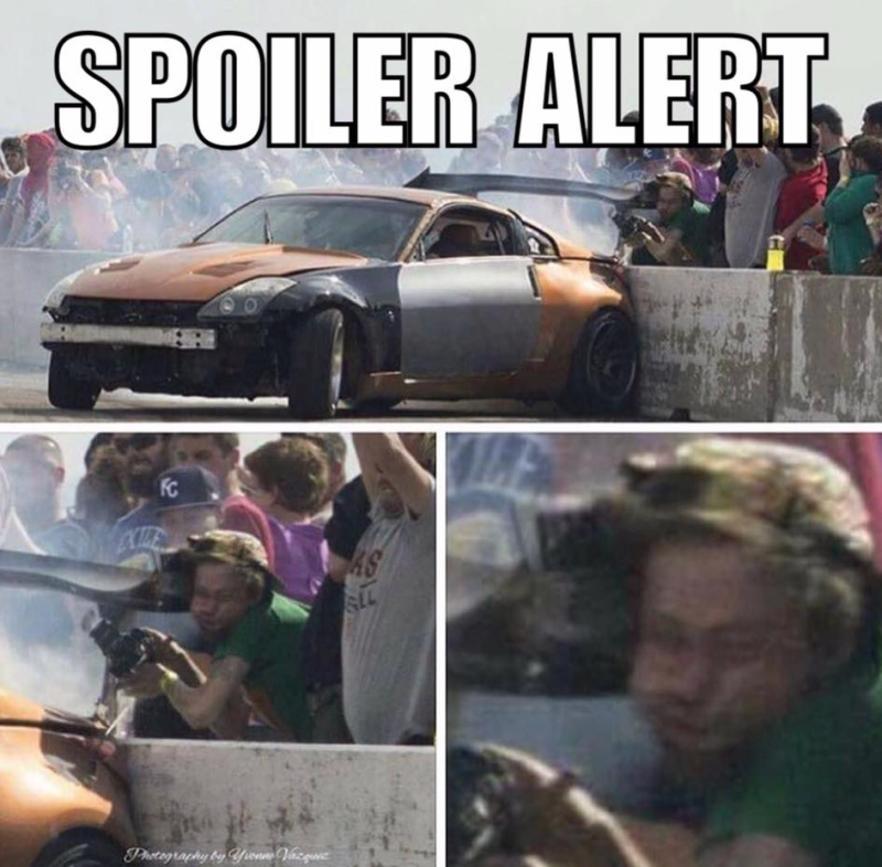 Spoiler Alert - man getting hit in the face with a spoiler from a race car.