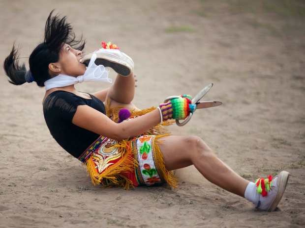 A scissors dancer puts her foot in her mouth during the national scissors dance competition held on the outskirts of Lima, Peru, in December.