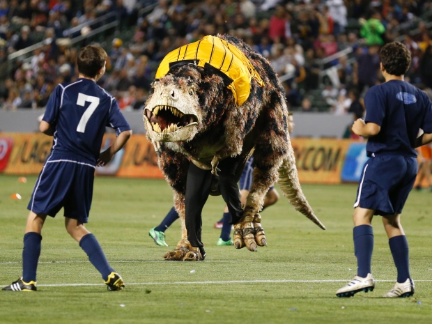 A person in a Tyrannosaurus rex costume runs on the field during an exhibition soccer match between MLS teams the Los Angeles Galaxy and Seattle Sounders FC in Carson, Calif., in May.