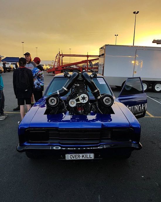Overkill car with massive engine coming out the hood.