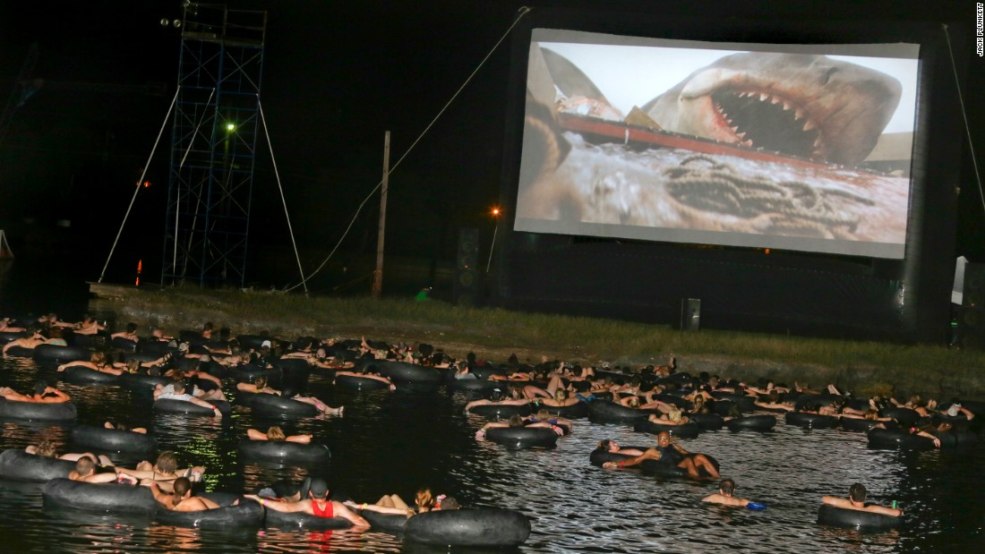 cool picture of watching the movie Jaws in a lake while floating on inner tubes