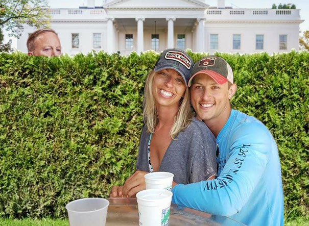 Engaged couple photoshopped to in front of the hedges of the White house with Sean Spicer peaking over it.