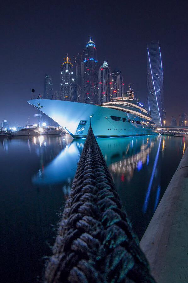 Awesome photo of a docked Yacht with a city backdrop.
