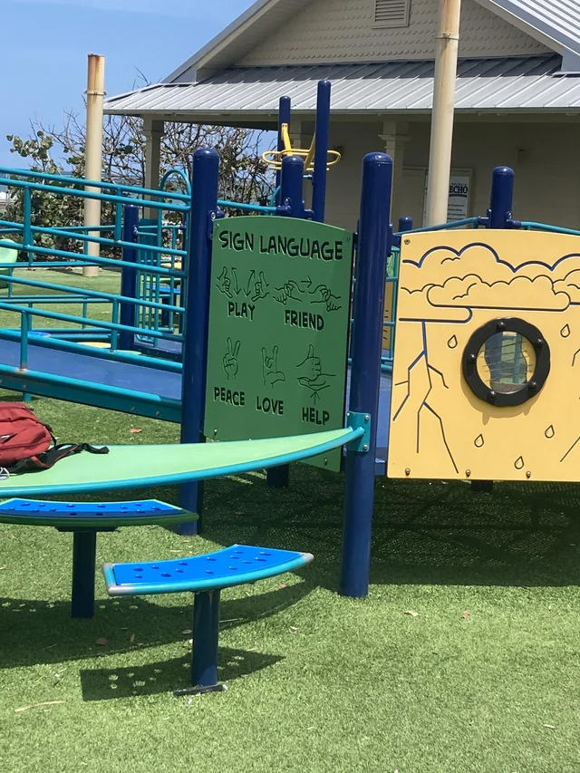 This playground has a sign with sign-language phrases on it so the deaf children can play and have friends too.