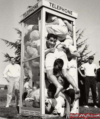 funny picture of a football team of men in black and white crammed into an old school telephone booth