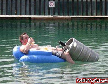 funny picture of man floating in a pool with keg floating next to him which he is drinking out of