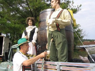 A guy getting some beer from a person's spout.