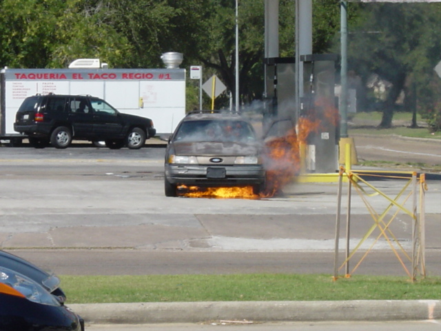 This happened accross from my work place. Two Hispanic guys pull up to the pumps at the local gas station with a little bit of smoke commong out of their hood, then all of a sudden they both get out and start running mabye drunk or the car was stolen. The longer the car sits the more smoke starts comming out, then flames are visiable under the car. Then it turned into this that you see in the picture. I have to say it ws pretty smart of those guy to park a car that is about to catch fire right next to the gas pumps.