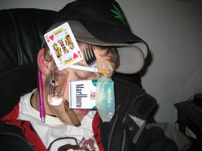 Freind passed out so we glued stuff to his face- shot glass, pen, condom, half a cigar, the king of hearts, a fork, a cigarette, a pack of cigarettes, a quater, and a bottle cap.
