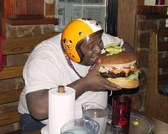 fat guy eats burger, more than he can handle