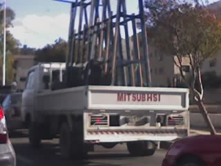 truck pictured on the road with mitsubishi spelled badly on the back.