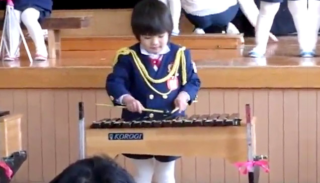 girl in school uniform playing xylophone