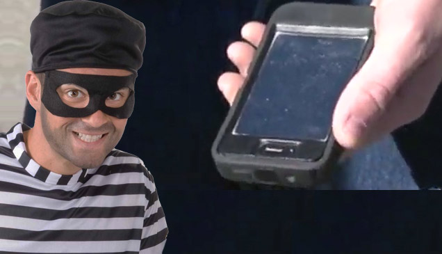 masked thief in striped shirt and hand holding iphone