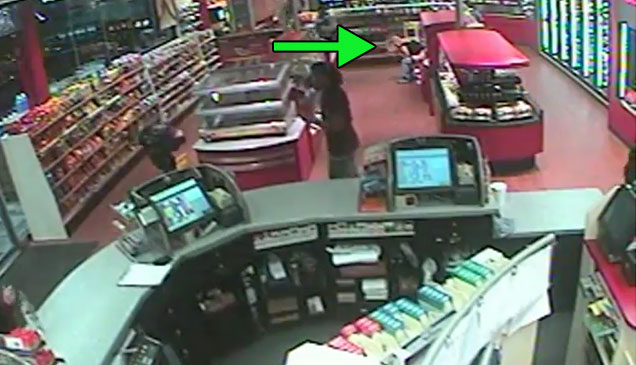 footage from a security camera of a store and a green arrow pointing at a person