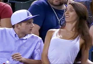 In a bold move, he surprises her at a baseball game and turns it on.
